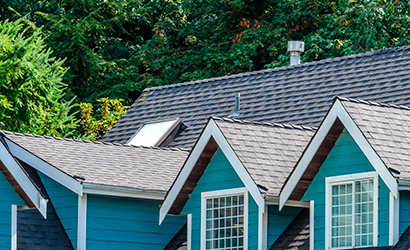 shingle roof on blue wooden house in the suburbs