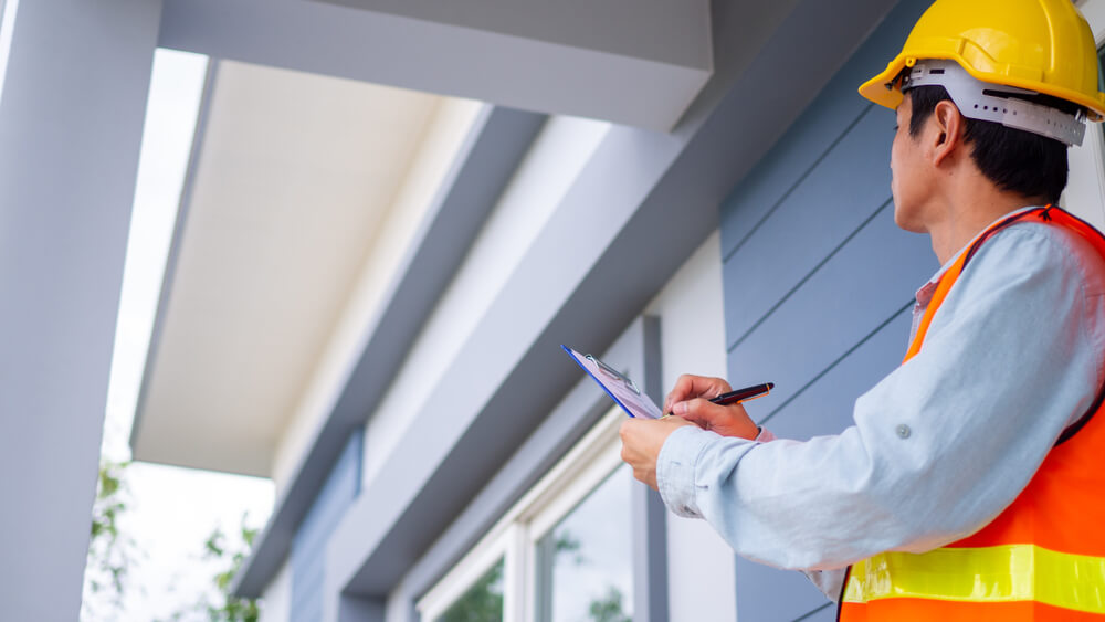 Roofer inspecting the roof of a residential property