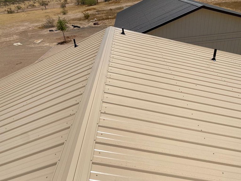 Beige R-panel sheets neatly installed on the roof, providing a clean and uniform look